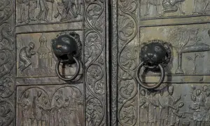 Drzwi gnieźnieńskie z lwimi uchwytami i misternymi płaskorzeźbami przedstawiającymi sceny biblijne i historyczne.