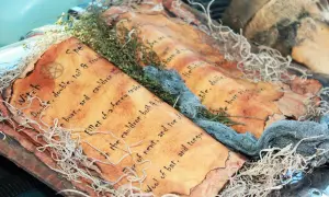 Stara księga zaklęć, ozdobiona gałązkami i sznurkami, przywołuje ducha dawnej **mitologii** i magii.