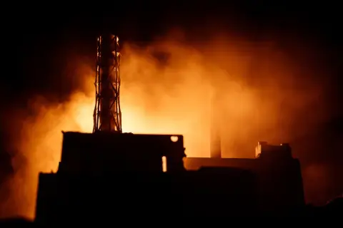 Mroczna sylwetka elektrowni, unosząca się mgła i pomarańczowe światło przywołują pamięć o tym, co wydarzyło się w Czarnobylu.
