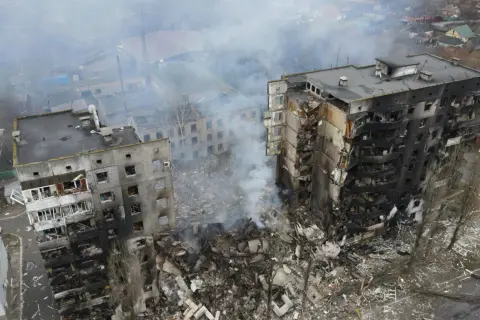 Zniszczone budynki mieszkalne, dym unoszący się nad gruzami, obraz tragedii, która rozpoczęła się, kiedy wybuchła wojna na Ukrainie.