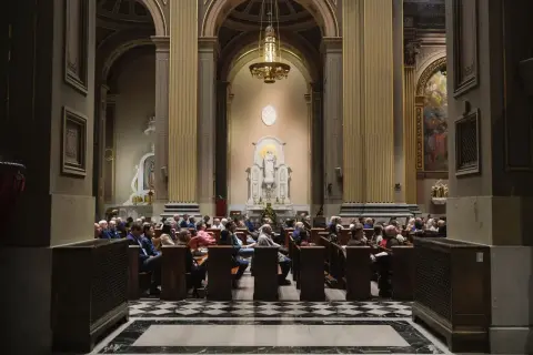 Wnętrze kościoła anglikańskiego z wiernymi siedzącymi w ławkach. W ołtarzu głównym znajduje się figura Matki Boskiej.