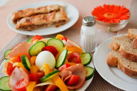 Kolorowa sałatka z jajkiem, wędliną i warzywami, obok pieczywo i ciasto. Czy dzisiaj jest post?