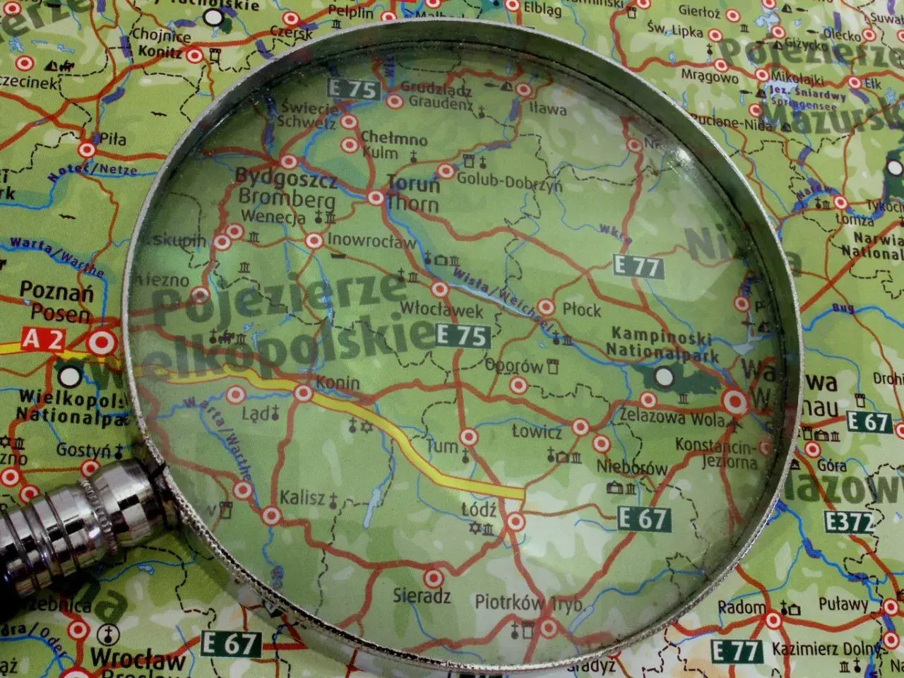 Pod lupą mapa Polski, szukamy odpowiedzi: ile jest miast w Polsce? Widoczne Poznań, Bydgoszcz, Toruń, Konin, Kalisz, Łódź.