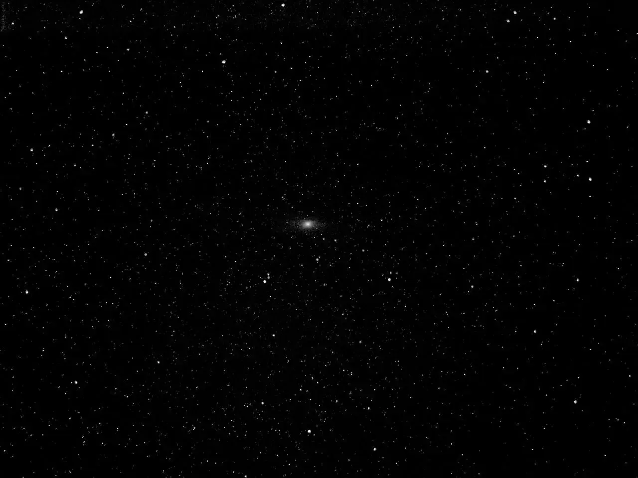 Mglista smuga galaktyki Andromeda na tle gwiezdnego nieba.