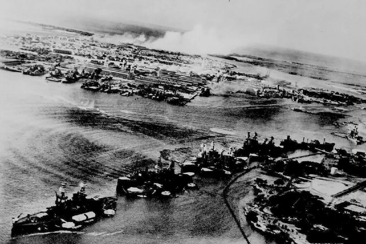 Widok z lotu ptaka na port, gdzie widać okręty i dym unoszący się po ataku na Pearl Harbor.
