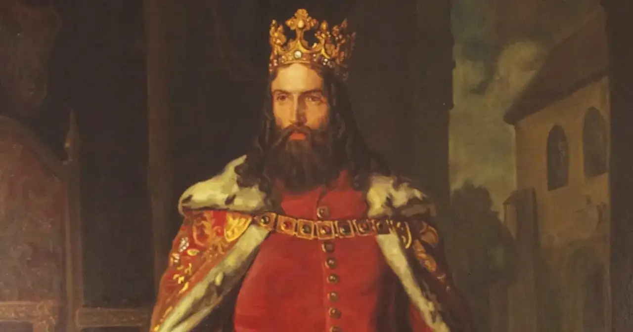 Portret króla z koroną na głowie i brodą, ubranego w czerwony strój i futrzany płaszcz. Ten dumny książę spogląda wprost na widza.