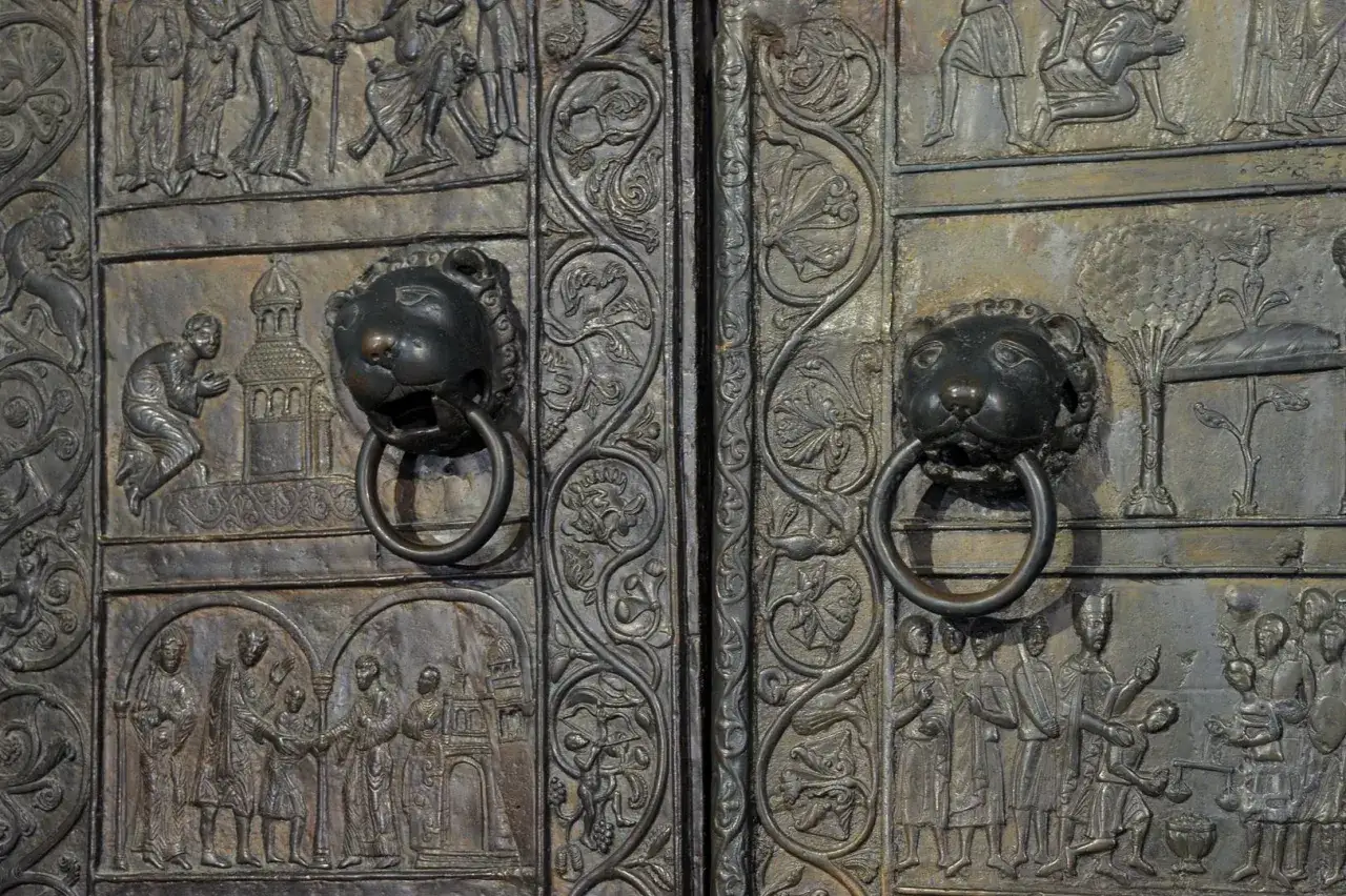 Bogate płaskorzeźby zdobią drzwi gnieźnieńskie, ukazując sceny biblijne i historyczne. Lwie głowy z kołatkami dodają im majestatu.