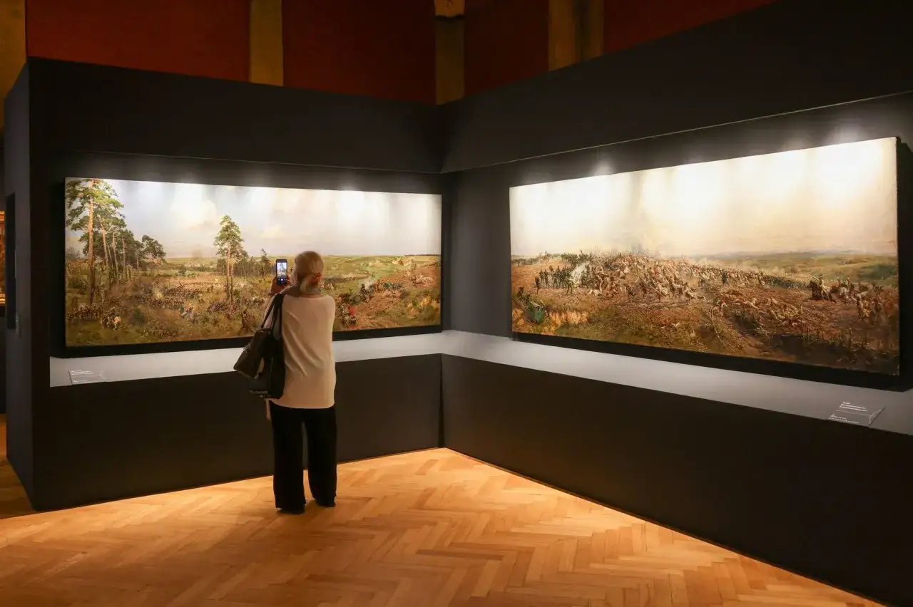 Kobieta fotografuje telefonem monumentalny obraz