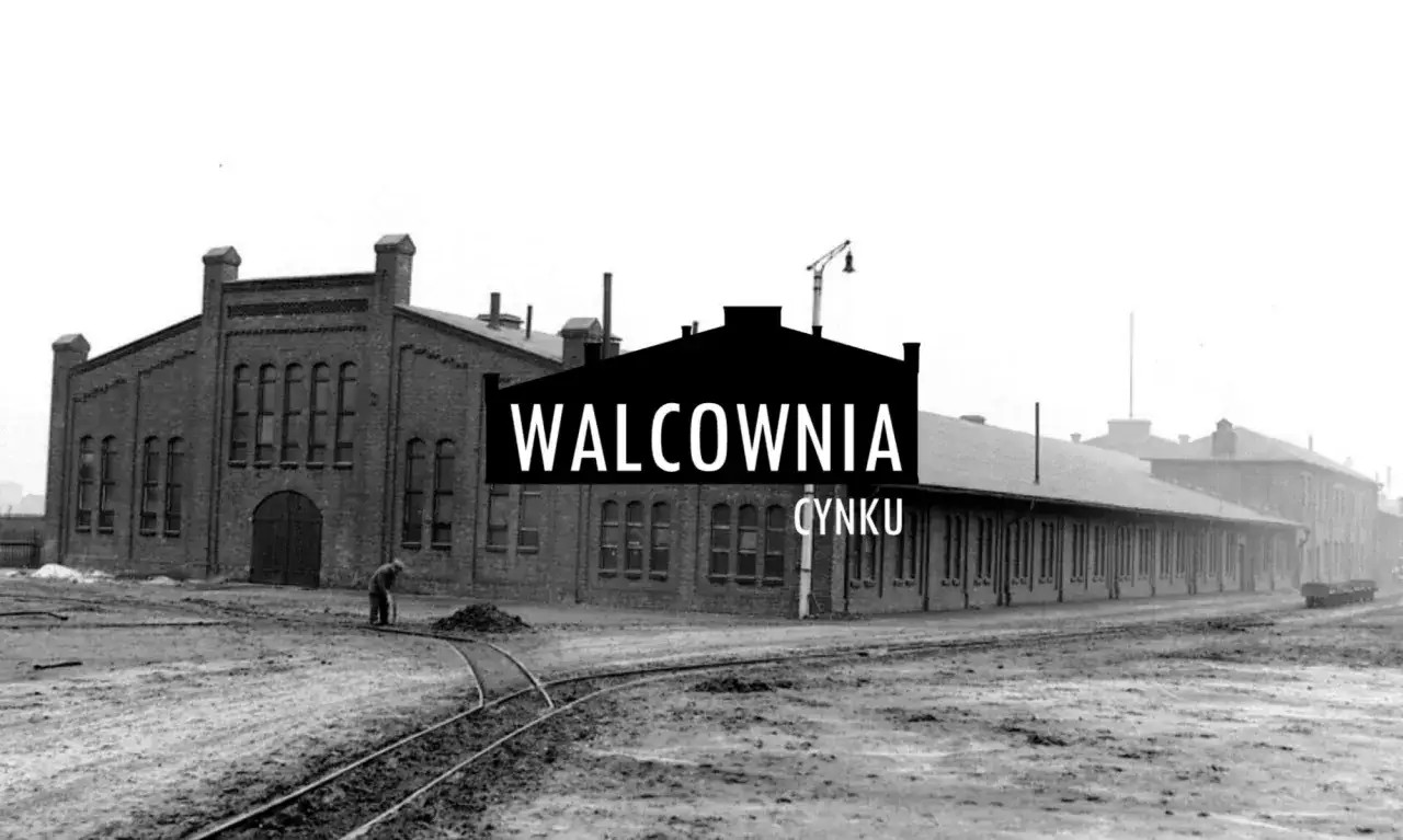 Dawna walcownia cynku w Szopienicach. Pracownik porządkuje teren przy torach kolejowych przed ceglanym budynkiem.