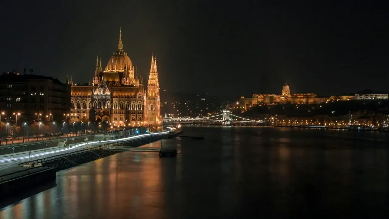 Nocny rejs po Dunaju w Budapeszcie. Oświetlony Parlament i Zamek Królewski na wzgórzu tworzą magiczny widok.