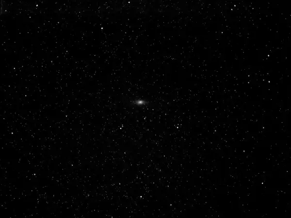 Mglista smuga galaktyki Andromeda na tle gwiezdnego nieba.