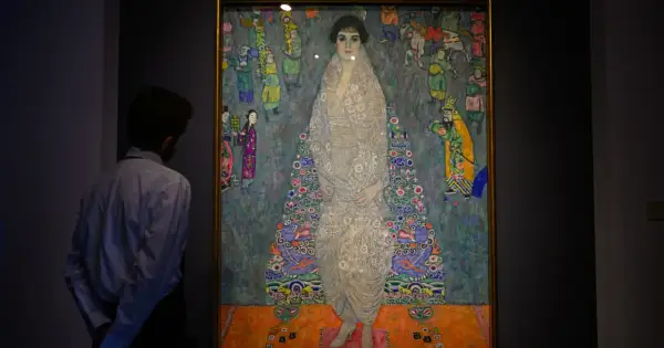Mężczyzna podziwia portret Adele Bloch-Bauer, najdroższy obraz świata. Dzieło Gustava Klimta zachwyca bogactwem wzorów i kolorów.